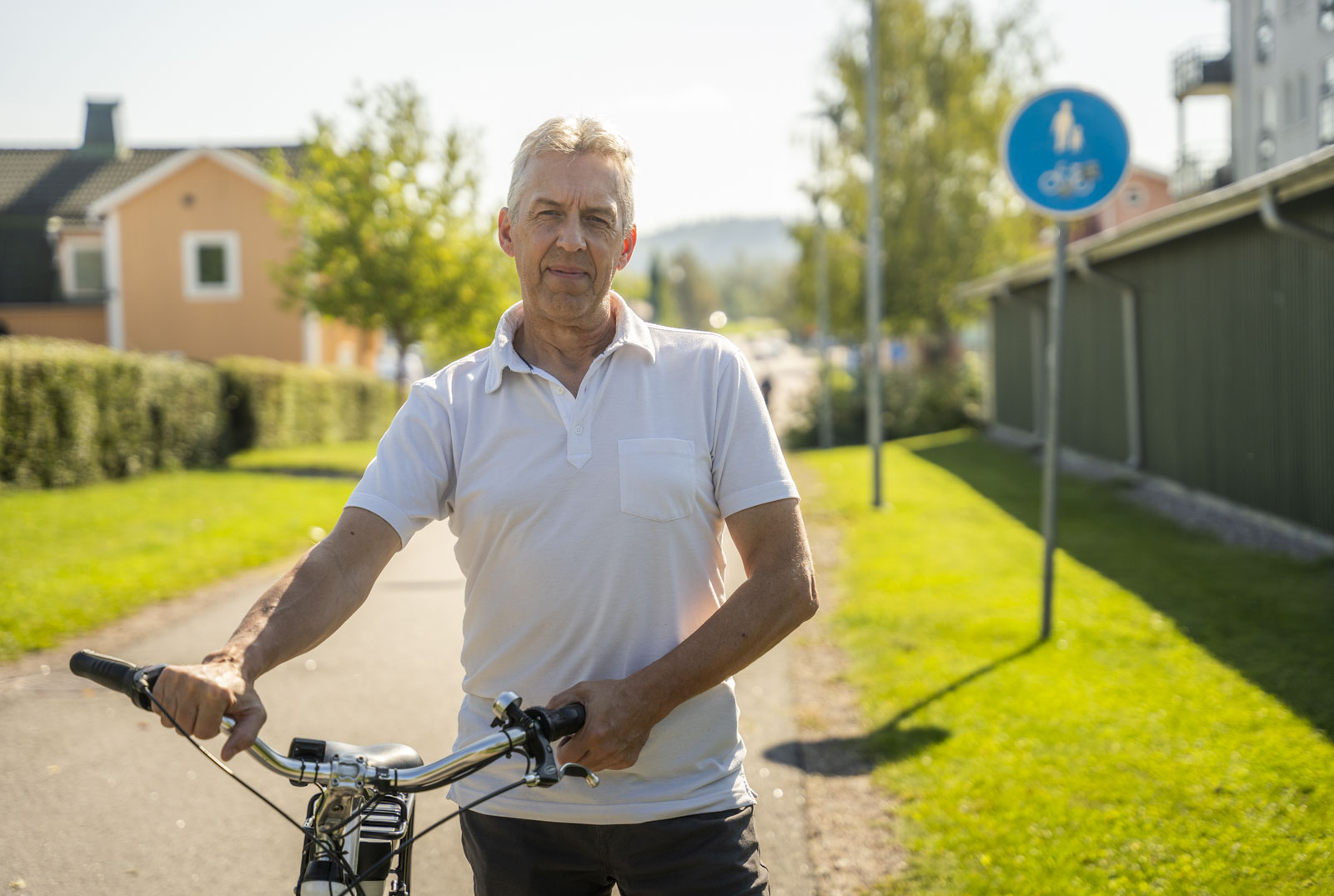 Teknisk chef Ulf Ståhlberg står med en cykel längs en gång- och cykelväg.