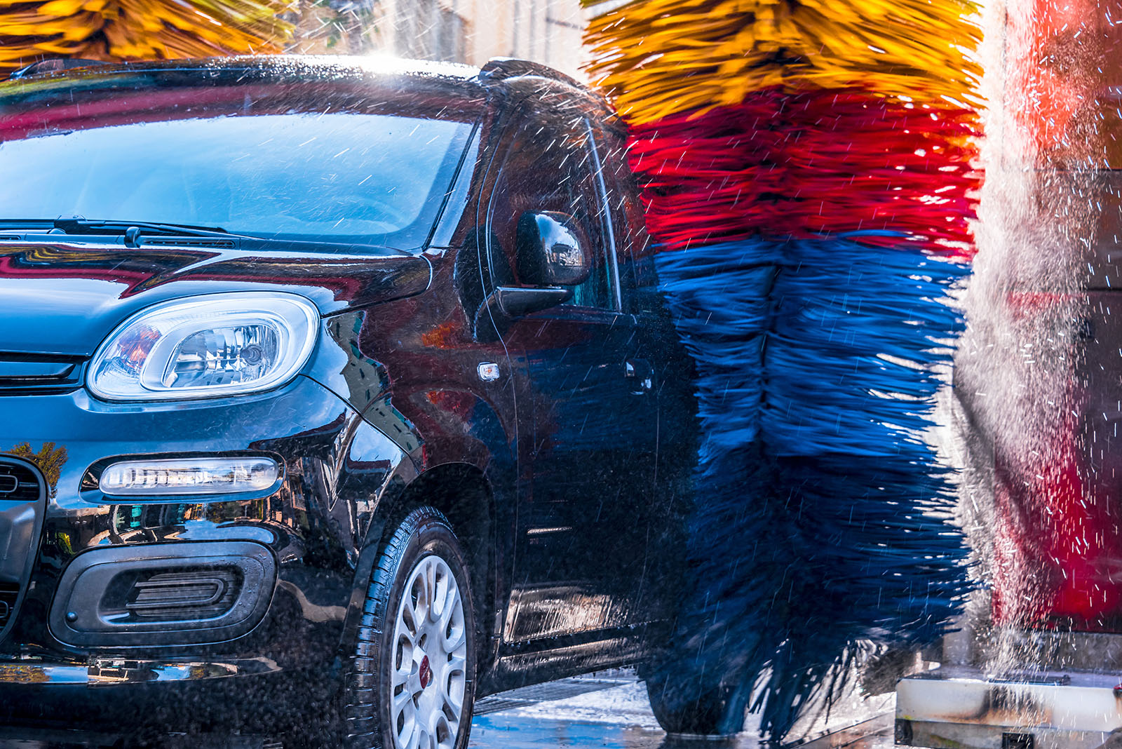 En bil blir tvättad i en biltvätt.
