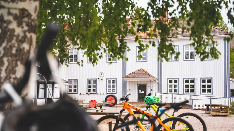 fasaden på knåda förskola med cyklar och lekplats i förgrunden