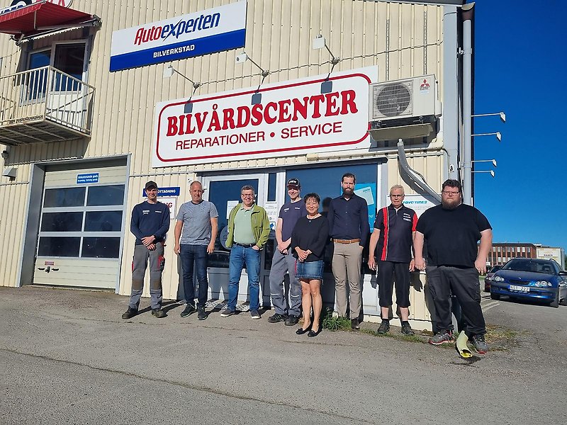 Flera personer står uppställda på rad framför Edsbyns Bilvårdscenter.