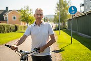 Teknisk chef Ulf Ståhlberg står med en cykel längs en gång- och cykelväg.