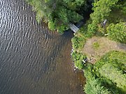 Ett flygfoto över en damm. I högra delen syns en grusväg och själva dammen. I den andra delen syns vatten från sjön stora Öjungen.