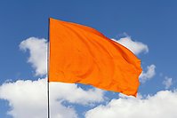 Orange flagga vajar i vinden